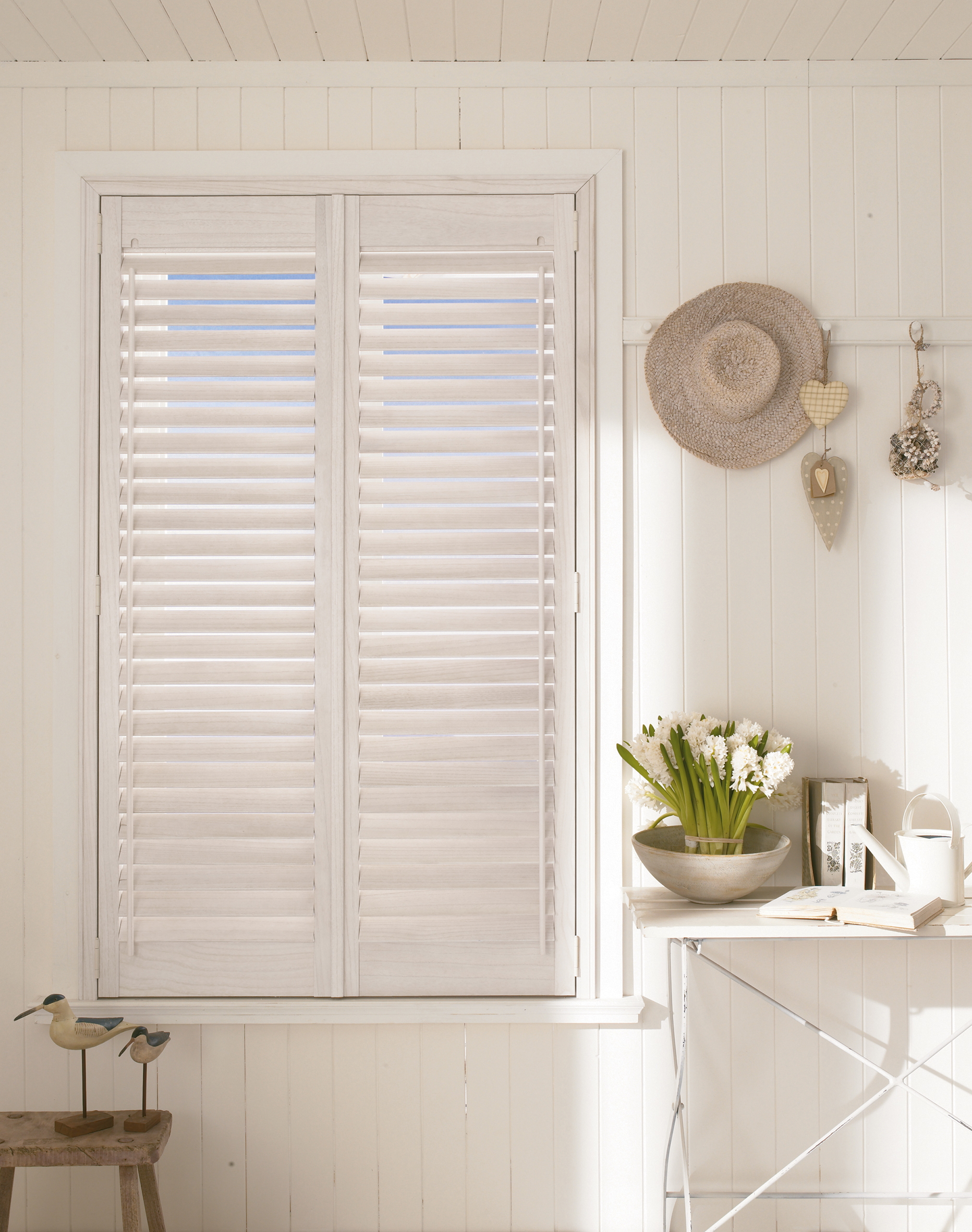 Matte white shutters in a panelled room