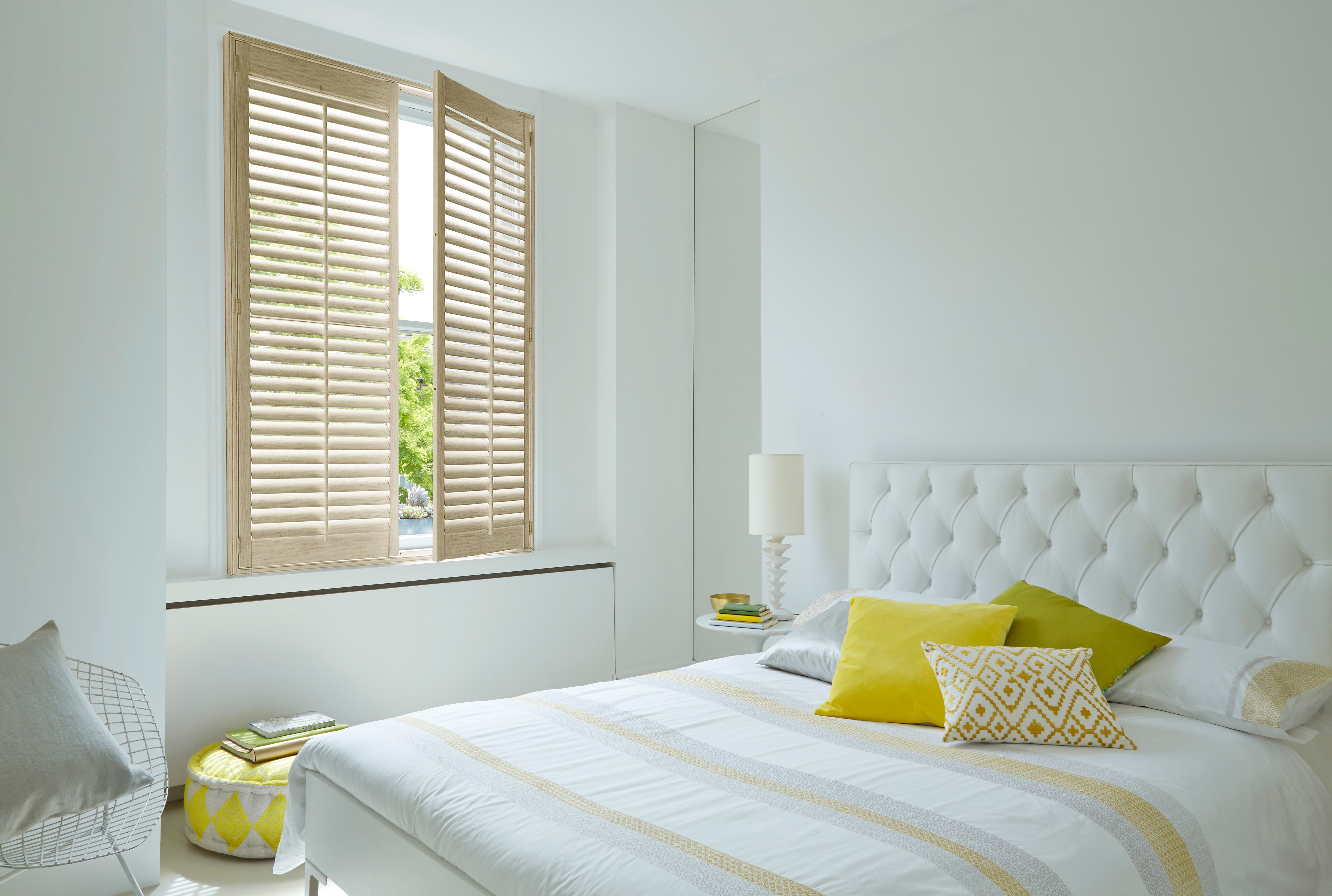 Oak shutters in a light-filled bedroom