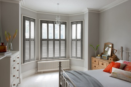 Weathered grey shutters fitted to a bay window